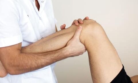 The doctor checks the knee for joint disease